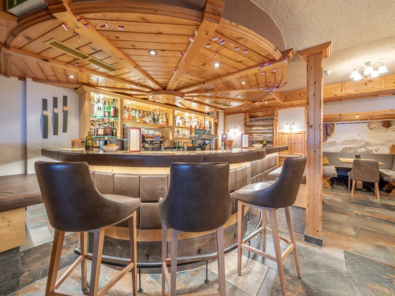Hotelbar im Burghotel Alpenglühn mit Holzdecke und runder Theke