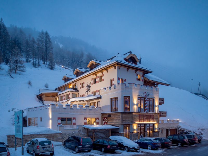 Das Burghotel Alpenglühn von außen bei Nacht in verschneiter Winterlandschaft