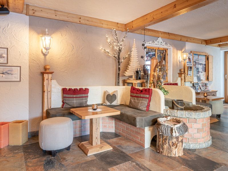 Alpenländisch dekorierte Lobby im Burghotel Alpenglühn mit Sitzecke und Naturmaterialien